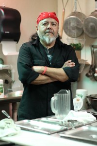 Dude Llanas stands in his kitchen, preparing for the night rush. 